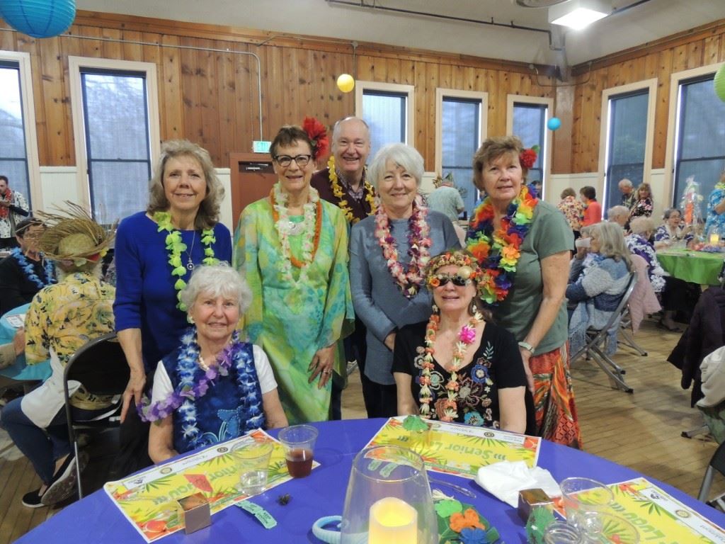 Group of people at table dressed in luau attire