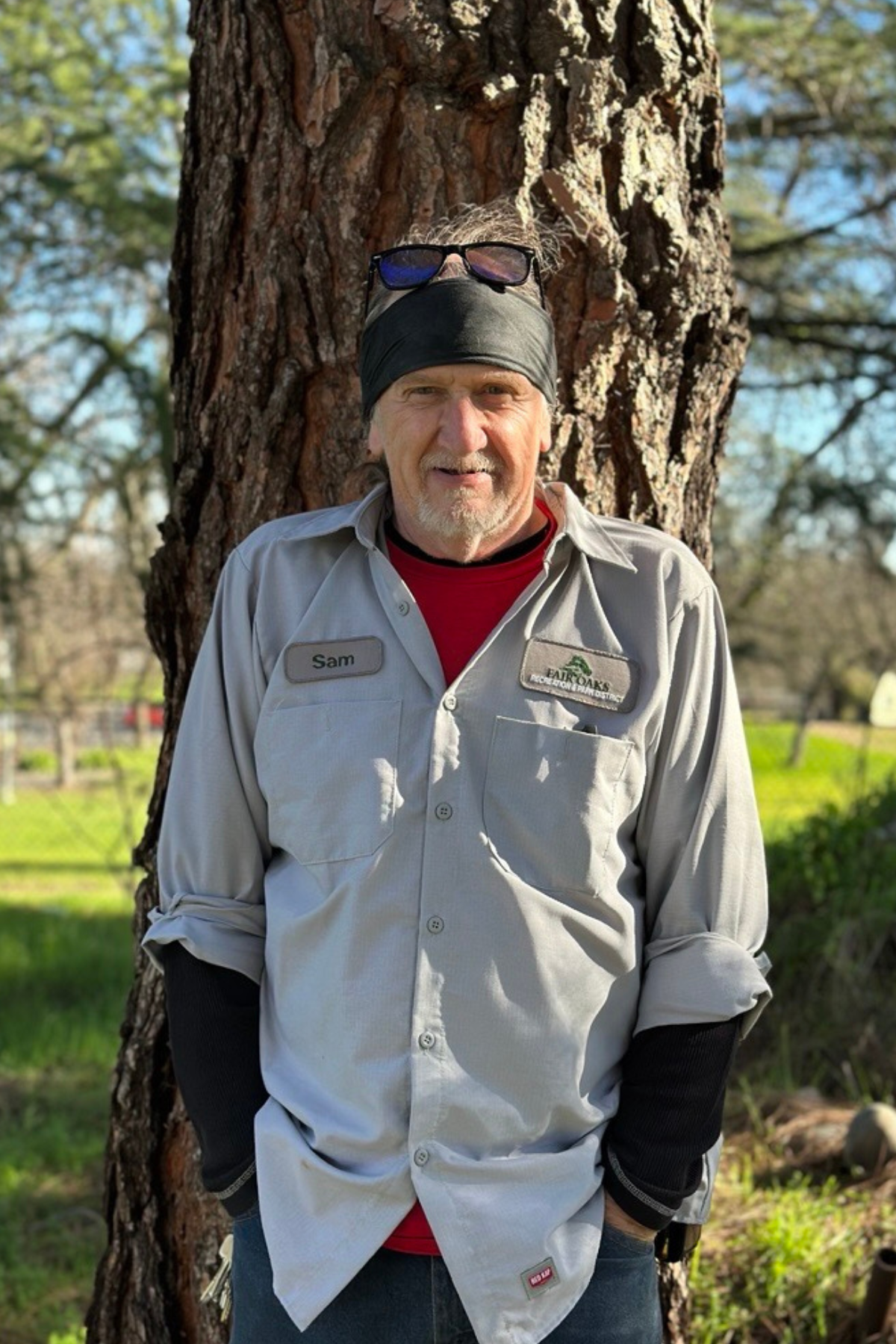 photo of a park worker standing in front of a tree