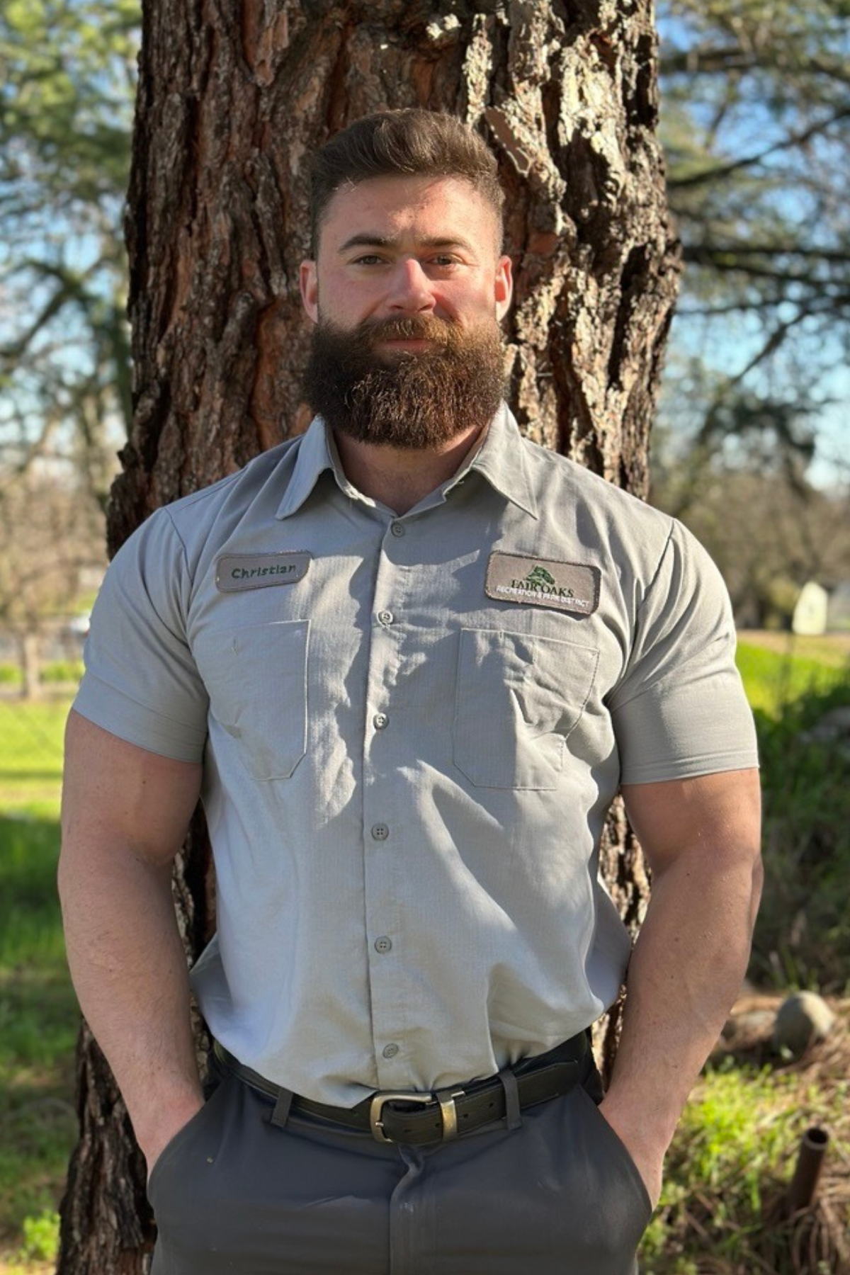 photo of a park worker standing in front of a tree